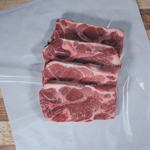 Four pork steaks on butcher paper