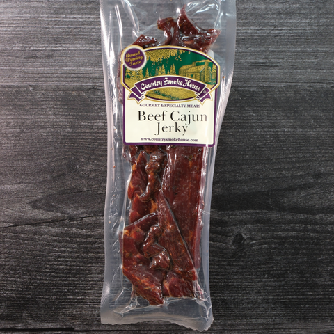 Packaged beef cajun jerky with a label on a wooden surface
