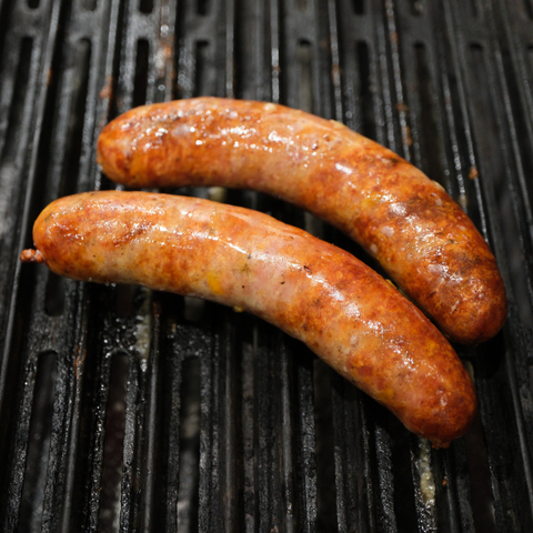Two Loaded Baked Potato Brats cooking on a grill