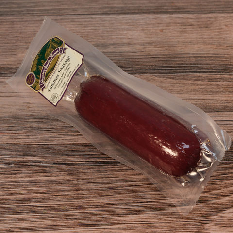 A packaged Summer Sausage on a wooden surface
