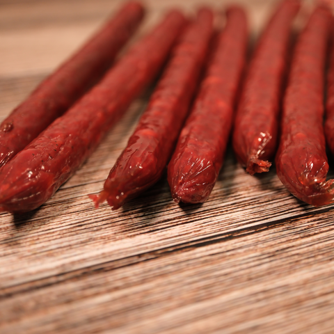 Close-up of Venison jalapeno cheese snack Sticks on a wooden surface