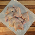 Five pounds of chicken leg quarters on butcher paper