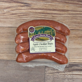 Packaged Apple Cheddar Brats on a wooden surface.