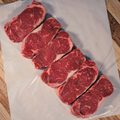 Six angus new york strip steaks on butcher paper