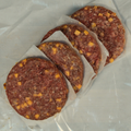 Four bacon and cheddar burger patties on butcher paper