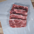 Four pork steaks on butcher paper