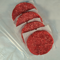 Four steak and chuck burger patties on butcher paper