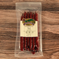 Packaged Beef BBQ Snack Stix with a label on a wooden surface
