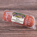 Packaged Beef Jalapeno Cheese Salami Chub on a wooden surface.