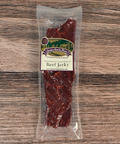 Packaged beef jerky with a label on a wooden surface