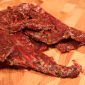 Close-up of beef peppered jerky on a wooden cutting board