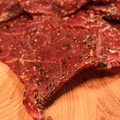 Close-up of beef peppered jerky on a wooden cutting board