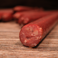 Close-up of a sliced Beef Salami Snack Stix on a wooden surface
