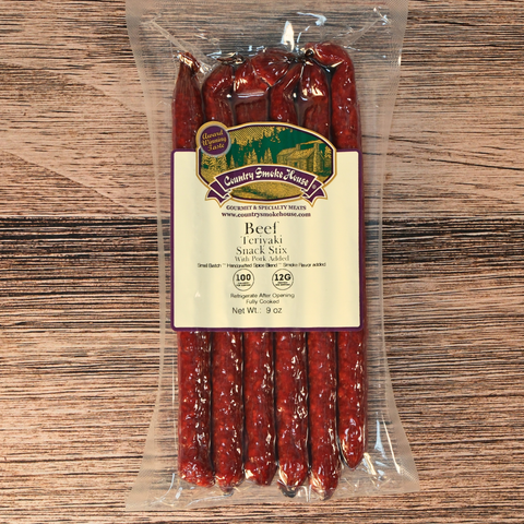 Packaged beef teriyaki snack sticks with a label on a wooden surface