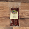 Packaged BBQ Buffalo Snack Stix with a label on a wooden surface