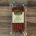 Packaged Buffalo Cheddar Cheese Snack Stix with a label on a wooden surface