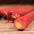 Close-up of a sliced Buffalo Cheddar Cheese Snack Stix on a wooden surface