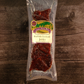 Packaged Buffalo Teriyaki Jerky on a wooden surface with a label