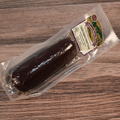 A packaged Cheddar Jalapeno Summer Sausage on a wooden surface