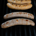 Grilled Cheeseburger Brats on a barbecue grill
