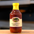 A bottle of Chicago Sweet BBQ Sauce placed on a wooden surface.