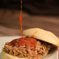 Close-up of a pulled pork sandwich with Chicago Sweet BBQ Sauce on a bun
