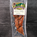 Packaged chicken BBQ jerky with a label on a wooden surface