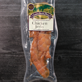 Packaged chicken jerky with a label on a dark wooden surface