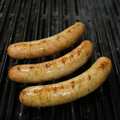 Three Dill Pickle Brats cooking on a grill