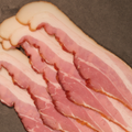 Close-up of Premium Sugar Cured Double Smoked Bacon on a dark surface