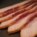 Close-up of Premium Sugar Cured Maple Bacon on a dark surface