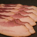 Close-up of Premium Sugar Cured Maple Bacon on a dark surface