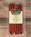 Packaged duck jalapeño cheese snack sticks with a label on a wooden surface