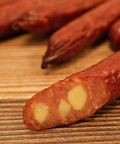 Close-up of a duck jalapeno cheese snack stick on a wooden surface