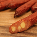 Close-up of a duck jalapeno cheese snack stick on a wooden surface