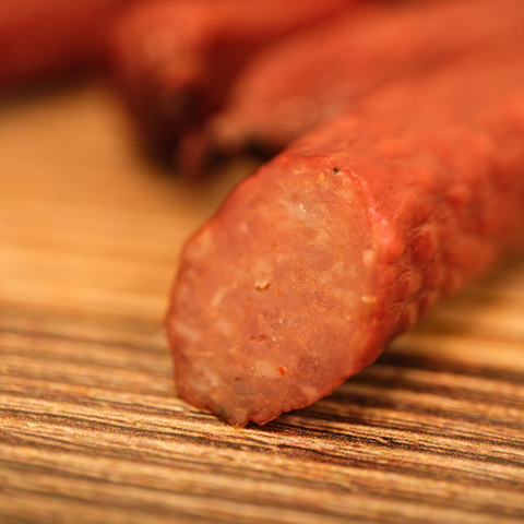 Close-up of a duck snack stick on a wooden surface
