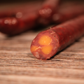 Close-up of a Elk Cherry Cheddar Snack Stix on a wooden surface