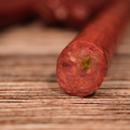 Close-up of a sliced Elk Jalapeno Pepper Snack Stix on a wooden surface