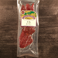 Packaged elk jerky on a wooden surface with a label