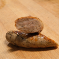 Sliced Garlic Parmesan Brat on a wooden surface