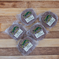 Five packages of half pound beef patties on a wooden surface