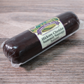 A Hickory Cheddar Summer Sausage Salami Chub on a wooden surface.
