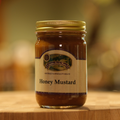 A jar of Country Smoke House Honey Mustard on a wooden surface.
