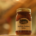 Jar of Medium Summer Salsa on a wooden surface
