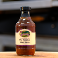 A bottle of Ole Smokey BBQ Sauce on a wooden surface.