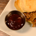 A side of Ole Smokey BBQ Sauce with a Pulled Pork sandwich