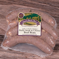 Packaged Philly Steak and Cheese Brats on a wooden surface.