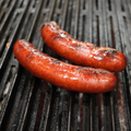 Two Smoked Pineapple Teriyaki Brats on a barbecue grill