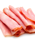 Slices of pink Polish ham stacked on a white background.