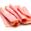 Slices of pink Polish ham stacked on a white background.